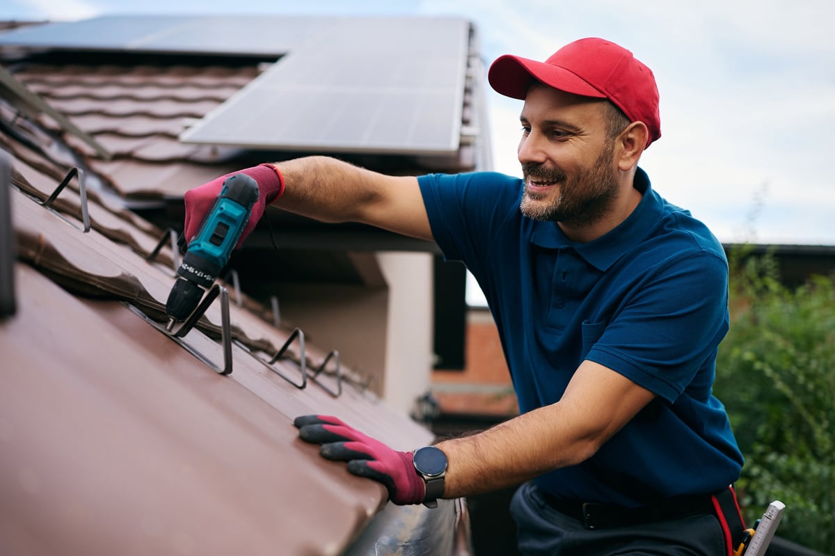 A contractor performing maintenance on the roof of a home